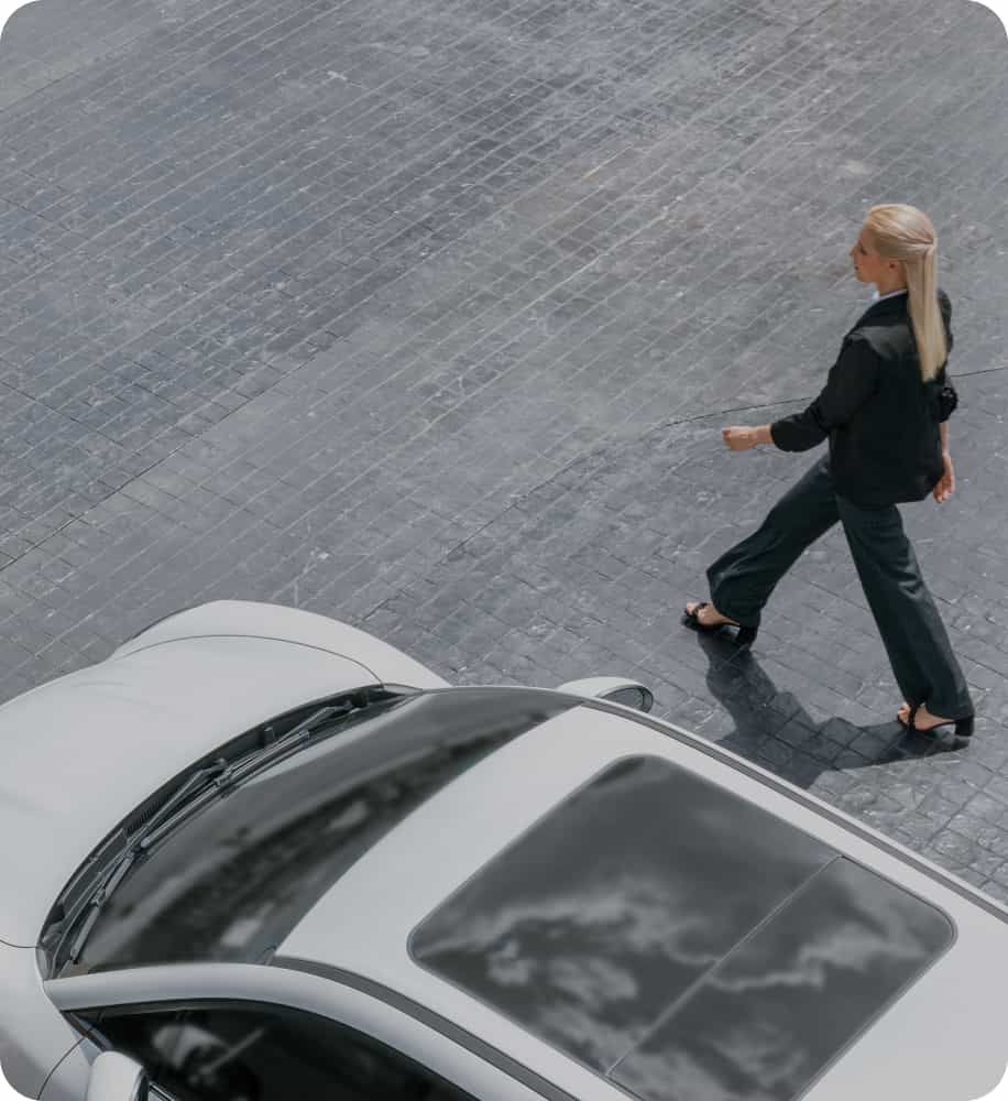 A person walking by a car